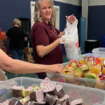 Beth Boehm, Human Resources Specialist at Brewer Science, puts donations in bags for the Hope Alliance Friday backpack program. 